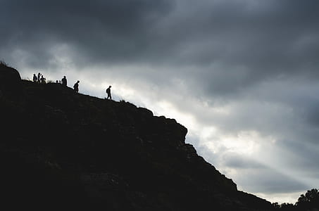 silhouette of person on top of mountain