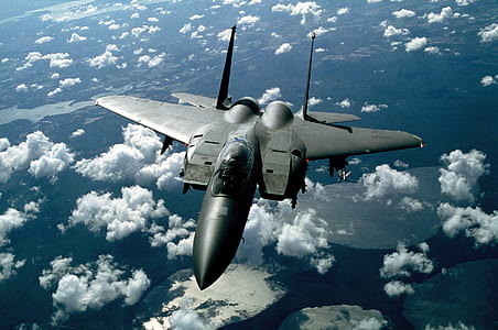 gray jet fighter above clouds during daytime