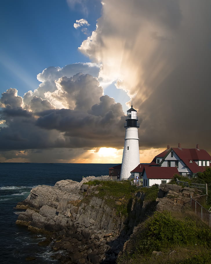 photo of white lighthouse near body of water