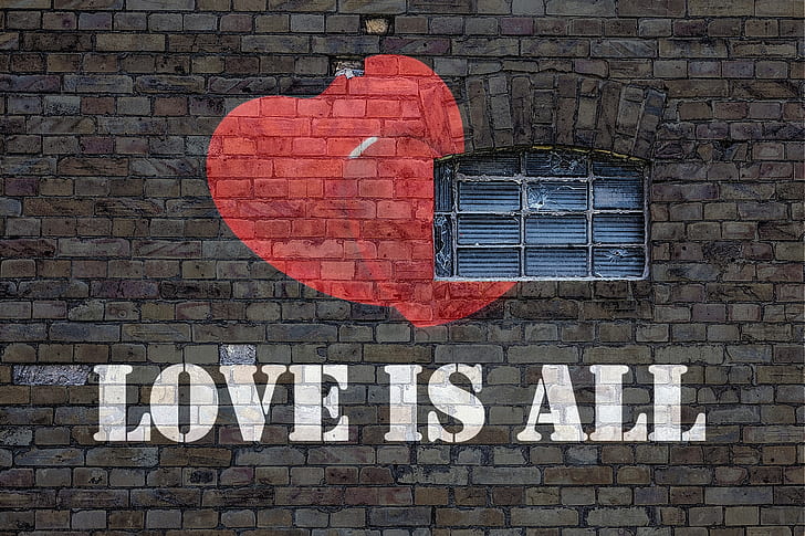 LOVE IS ALL painted brick wall