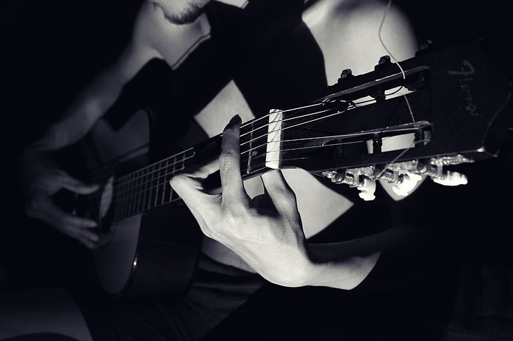 Closeup shot of a man playing a guitar
