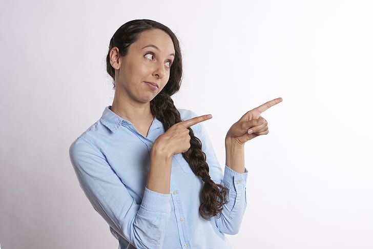 woman pointing her two index fingers on right side