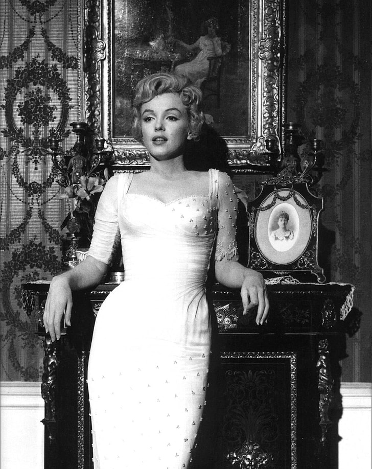 Marilyn Monroe leaning on fireplace mantel