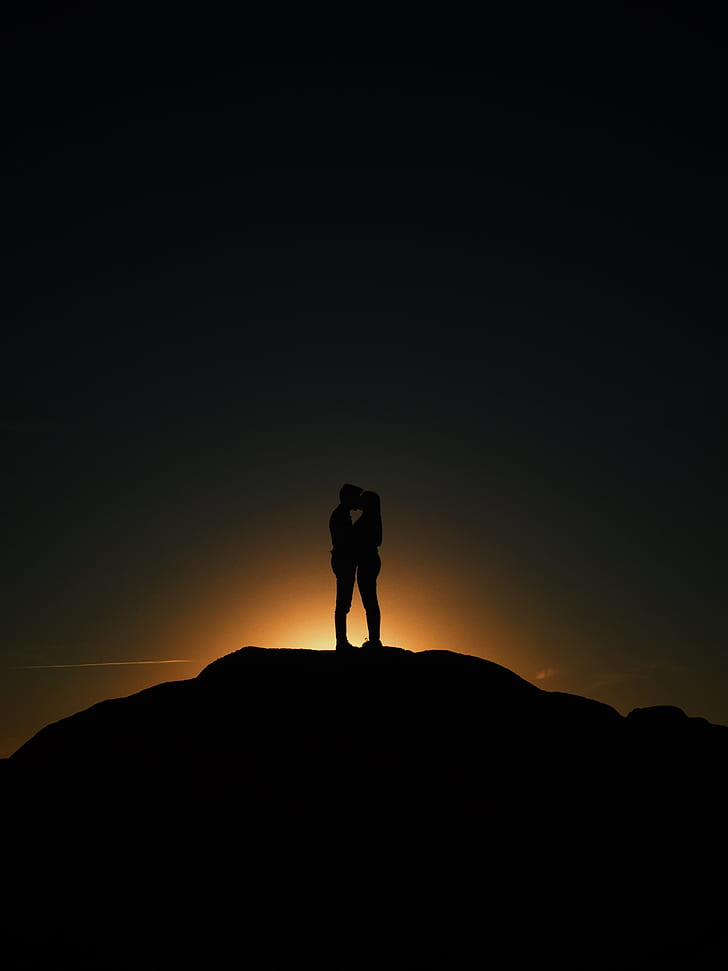 silhouette of two person kissing