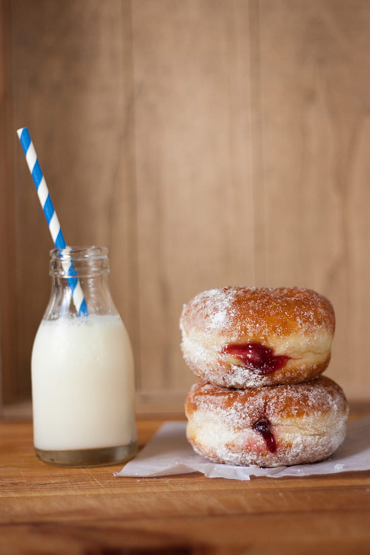 clear glass container and two doughnuts