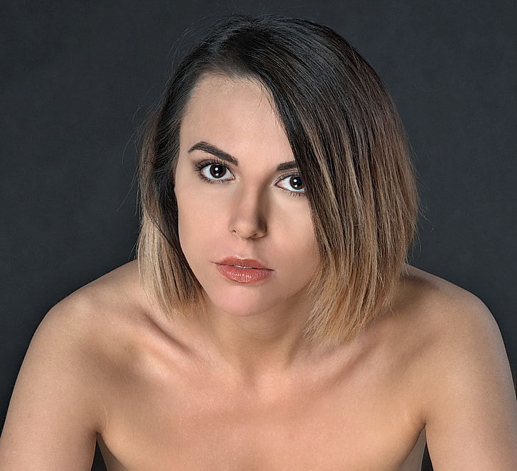 topless woman against black background