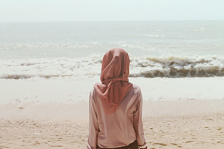 woman wearing pink hijab near body of water