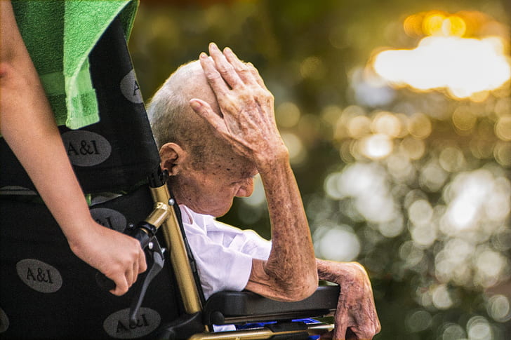 selective focus photography of man sitting on wheelchair