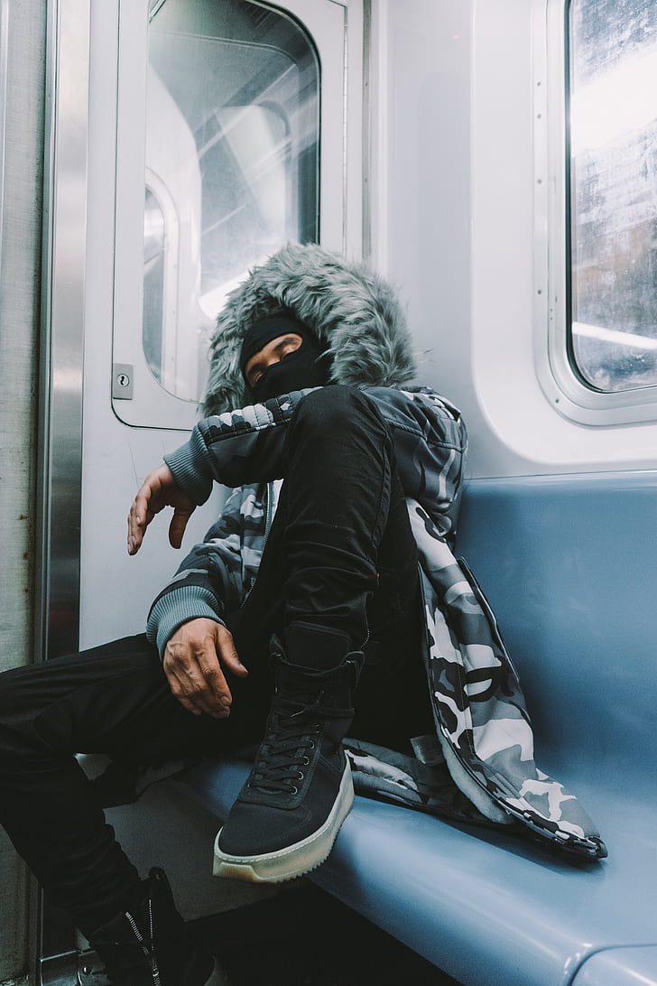 man wearing jacket on train sleeping