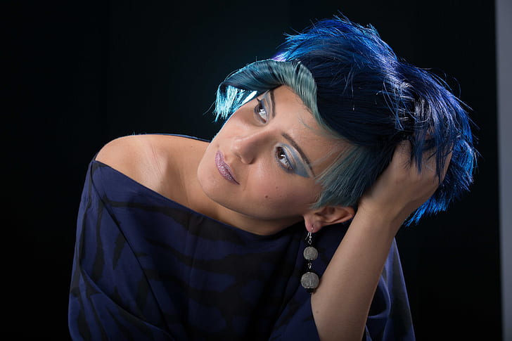woman with short blue hair wearing blue and black off-shoulder top