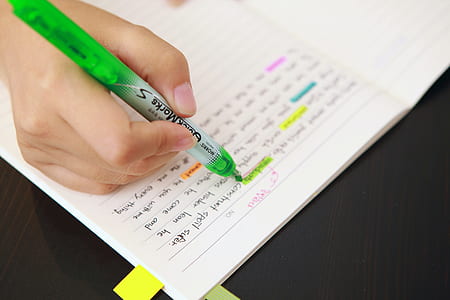 person using green highlighter pen