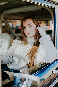 woman in white knit turtleneck sweater riding car