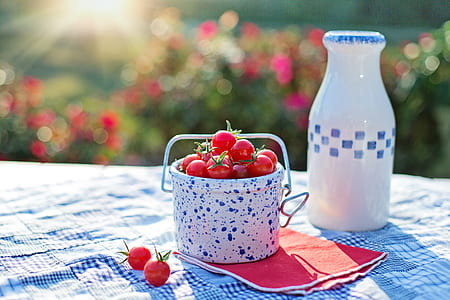 red cherries in white and blue ceramic bucket