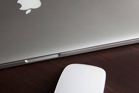 MacBook Pro laptop computer and Magic Mouse on a wooden desk