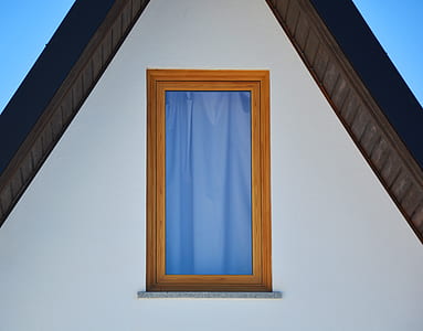 blue curtain as seen through window with wooden frame