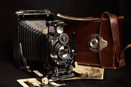 black folding camera with brown leather bag