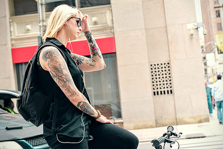 woman wearing black collared sleeveless top with black pants on bike