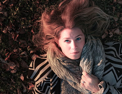 woman wearing scarf lying on the ground