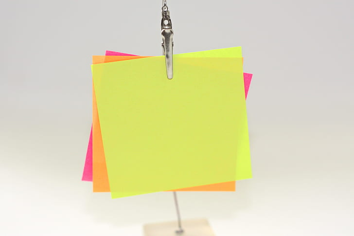 three assorted-color papers on metal clip