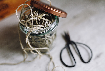 Thread in a jar and a paintbrush