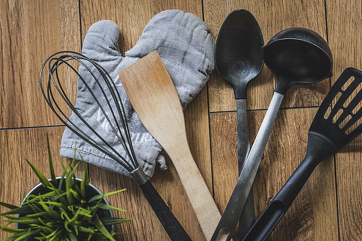 assorted kitchen utensils on brown wooden top