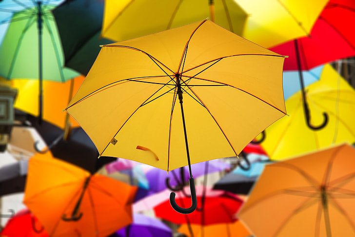 selective focus photography of yellow umbrella