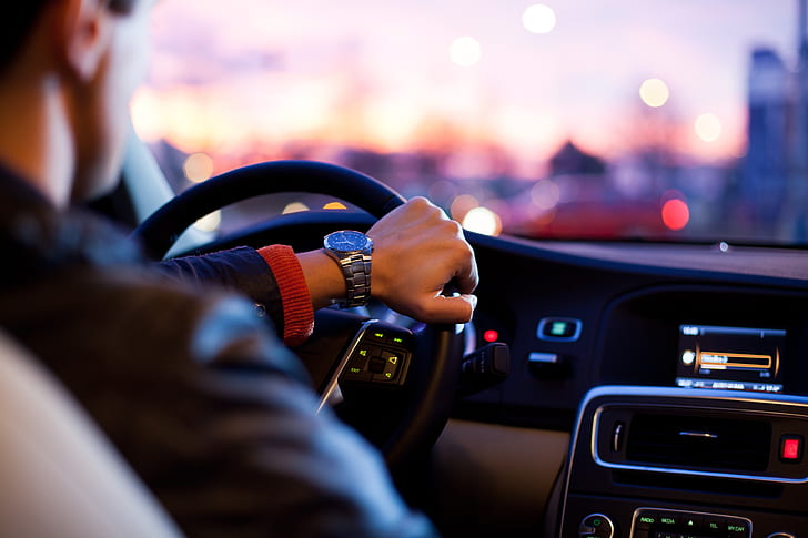 man in black jacket holding steering wheel