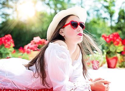 woman wearing white off-shoulder shirt and heart sunglasses