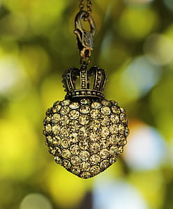 silver-colored pendant with clear gemstones