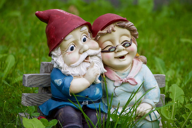 male and female dwarf seating on gray bench chair figurine