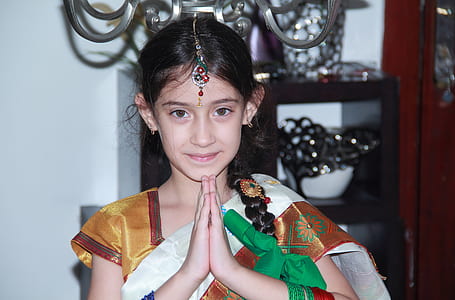 girl in brown sari dress prying