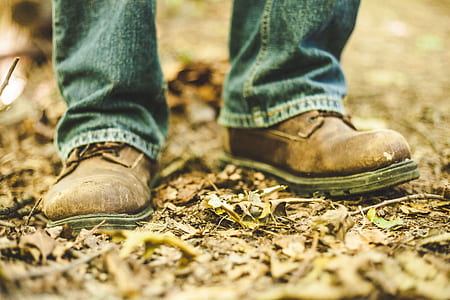 closeup photo of man wearing brown leather shoes and blue jeans