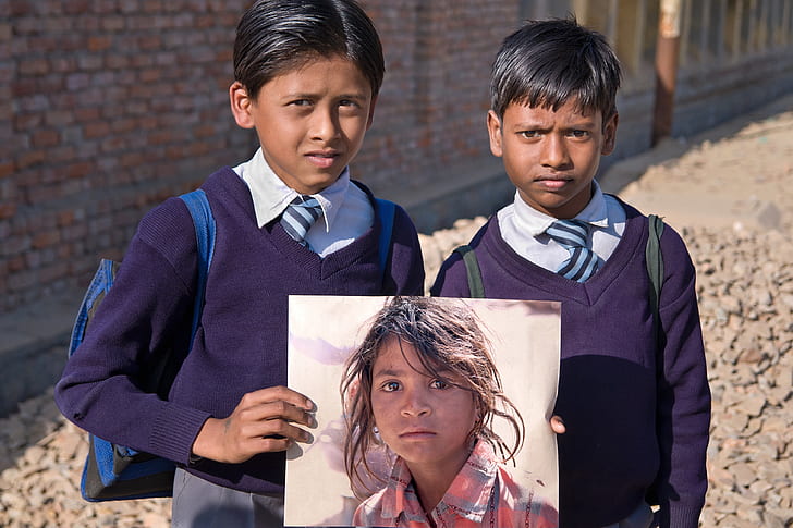 boy in purple sweater holding photo of a girl