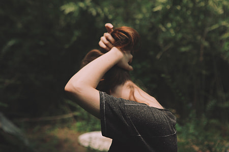 standing woman tying her hair at daytime