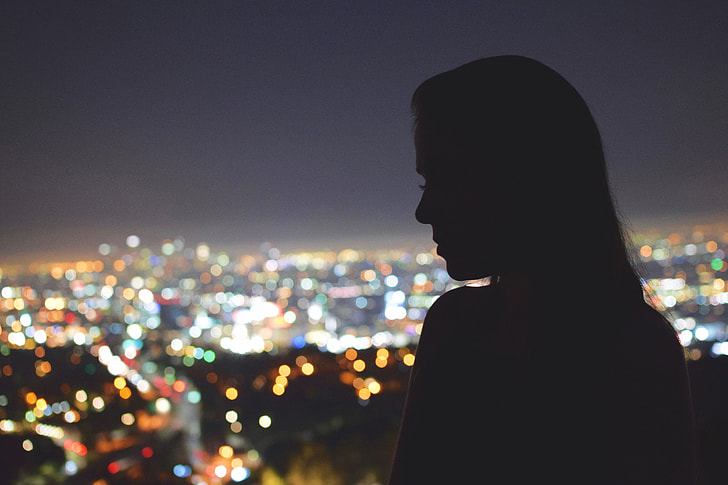 Silhouette of a woman looking over the city of Los Angeles at night