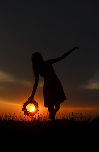 silhouette photography of woman surrounded by grass during golden hour