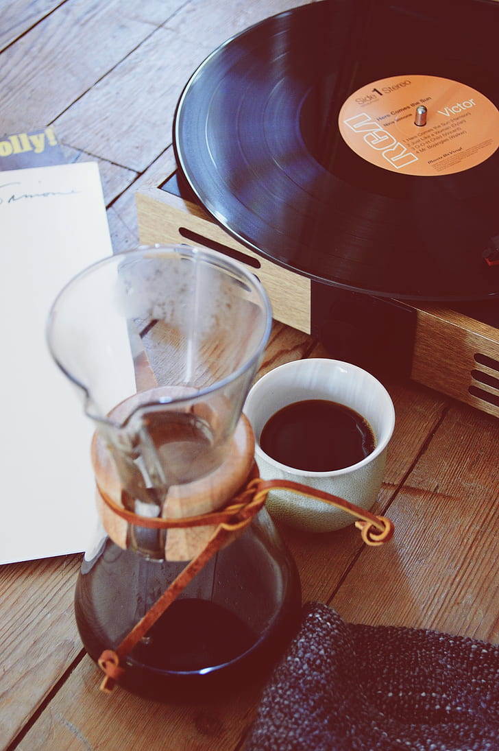 white ceramic mug with coffee inside beside black RCA vinyl record