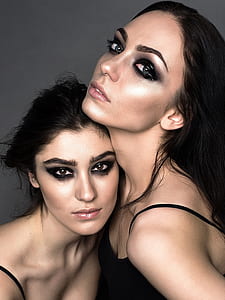 two women with makeup wearing spaghetti strap tops