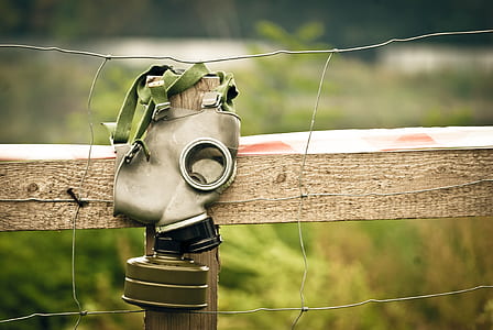gray gas mask hanging on wire fence