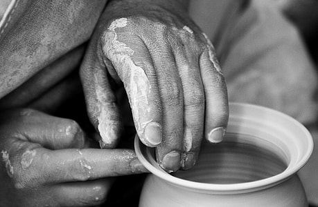 grayscale photo of person's hands molding pot