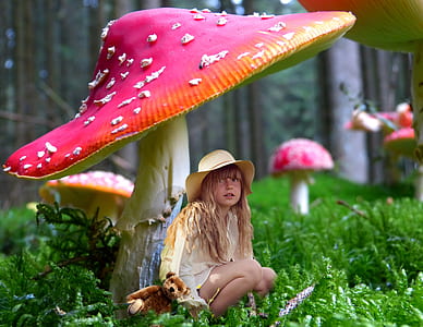 girl sitting under pink mushroom