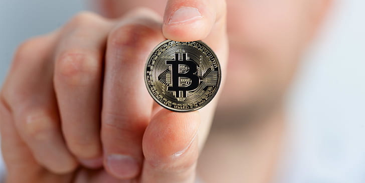 person holding Bitcoin coin