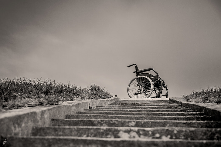grayscale photo of wheelchair on top of stairs