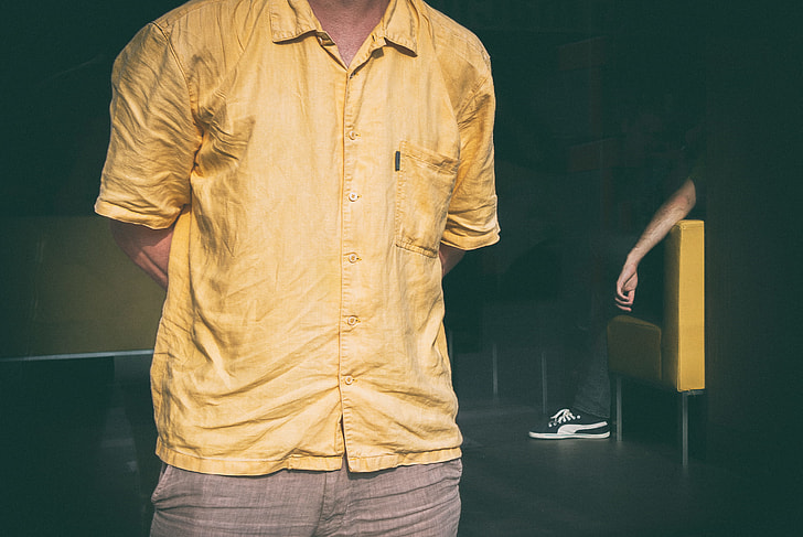 Cropped image of a man dressed in a yellow shirt. Image captured in Linz, Austria