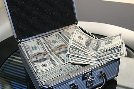 bundle of 100 US dollar banknote with silver briefcase