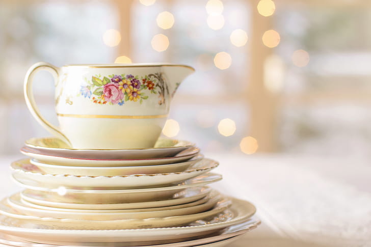 selective-focus photography of white-and-multicolored floral ceramic tea set