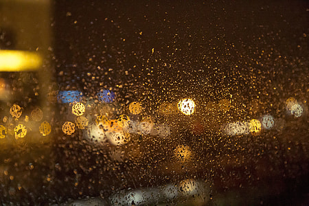 bokeh photography of water droplets on glass window