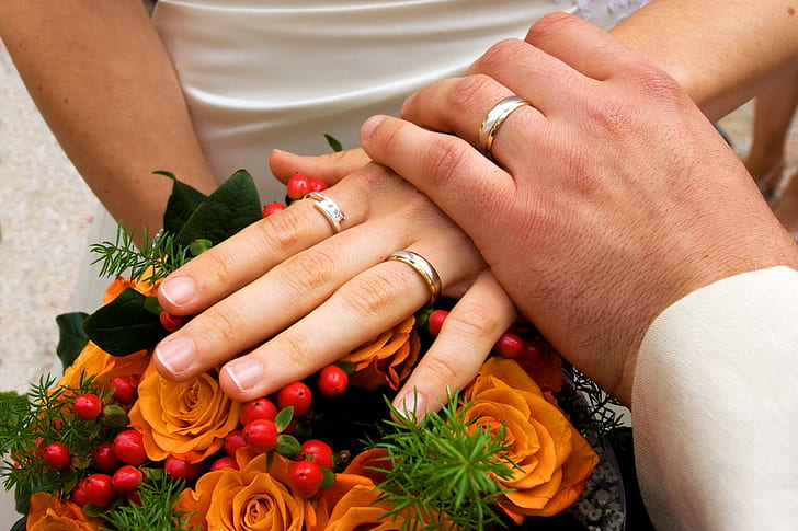 man holding woman wearing wedding bands