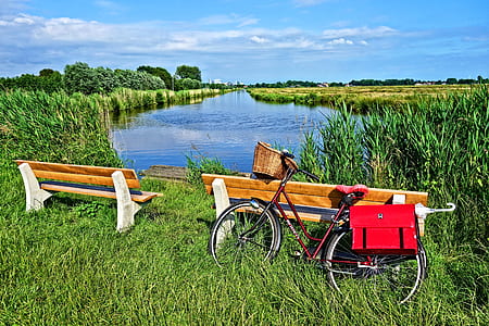 red dutch bicycle near wooden bench during daytime