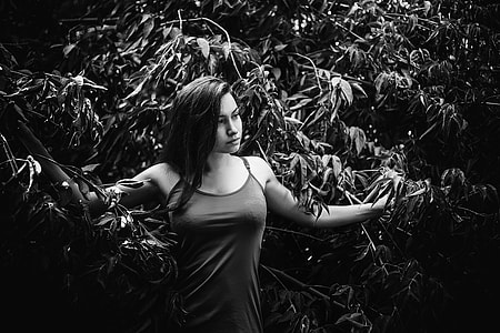 greyscale photography of woman near plants
